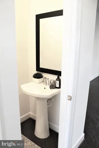a bathroom with a sink and mirror with toilet
