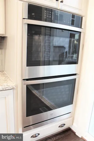 a kitchen with granite countertop white cabinets and a sink