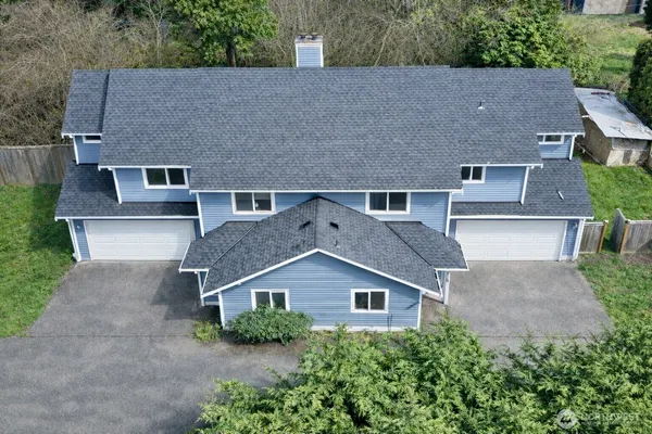 an aerial view of house with yard and trees in the background