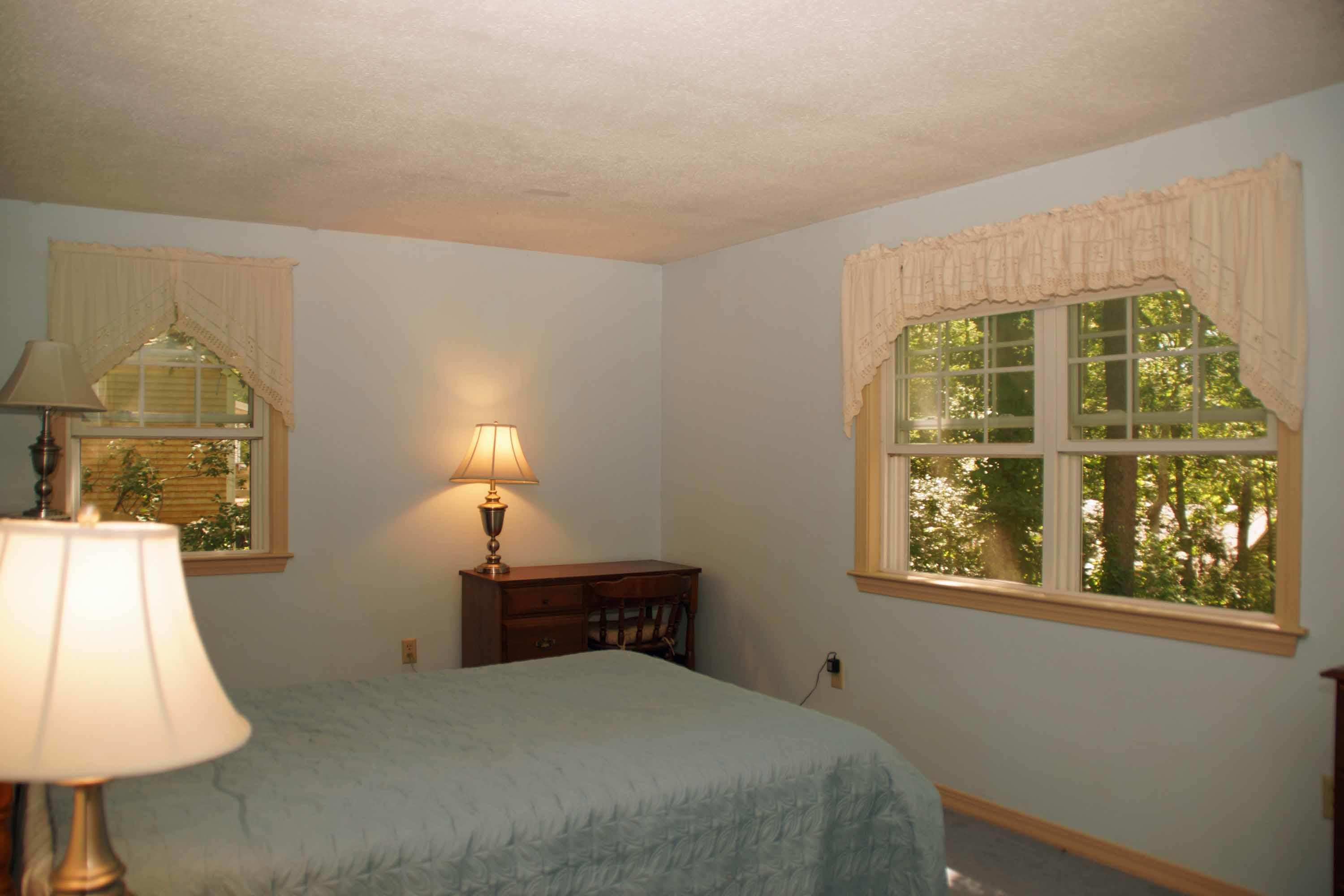 111 Azalea Drive Harwich, MA 02645 - Photo 12 of 26 a bedroom with a bed and a lamp on table