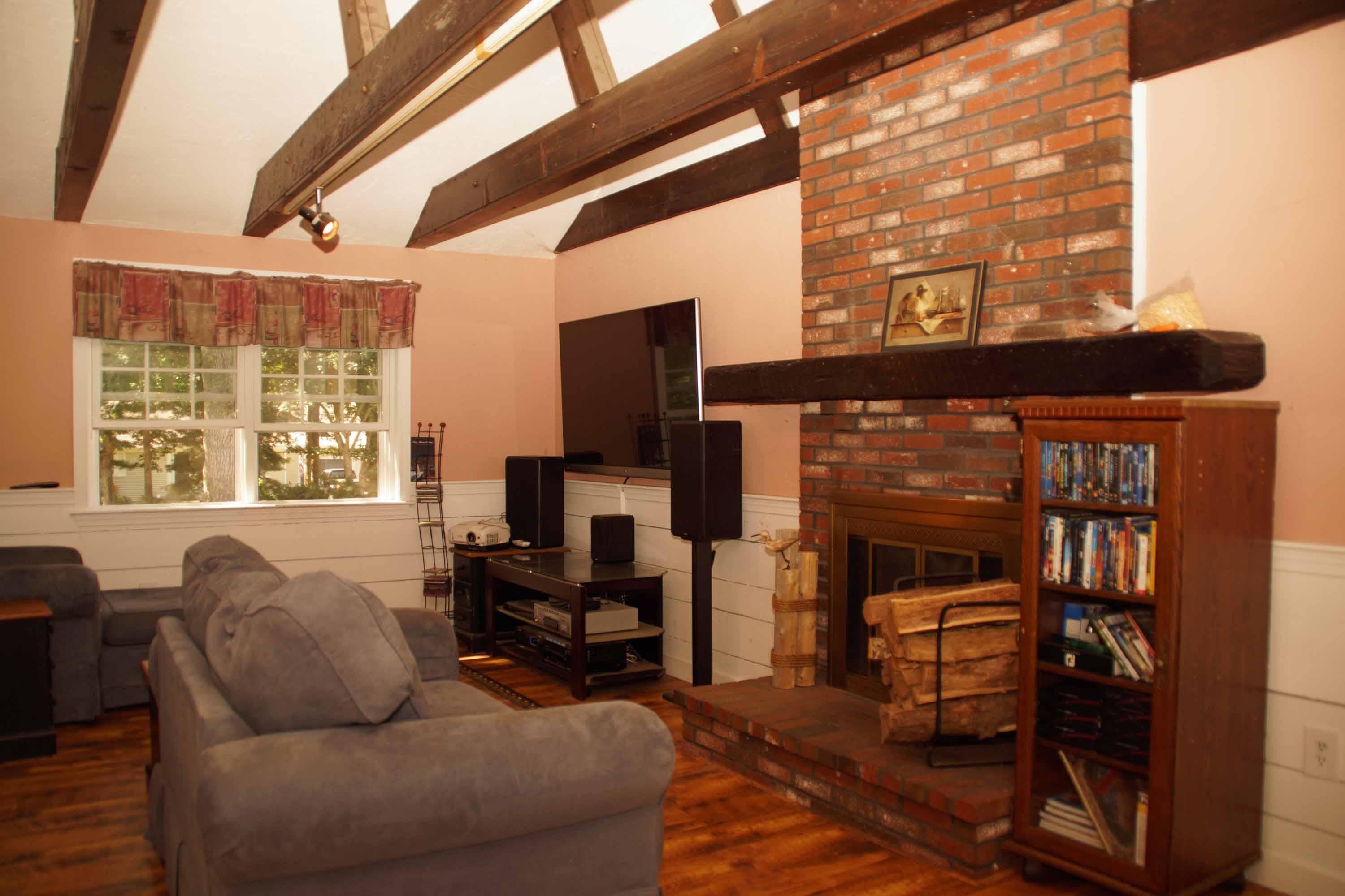 111 Azalea Drive Harwich, MA 02645 - Photo 4 of 26 a living room with furniture a fireplace and a large window