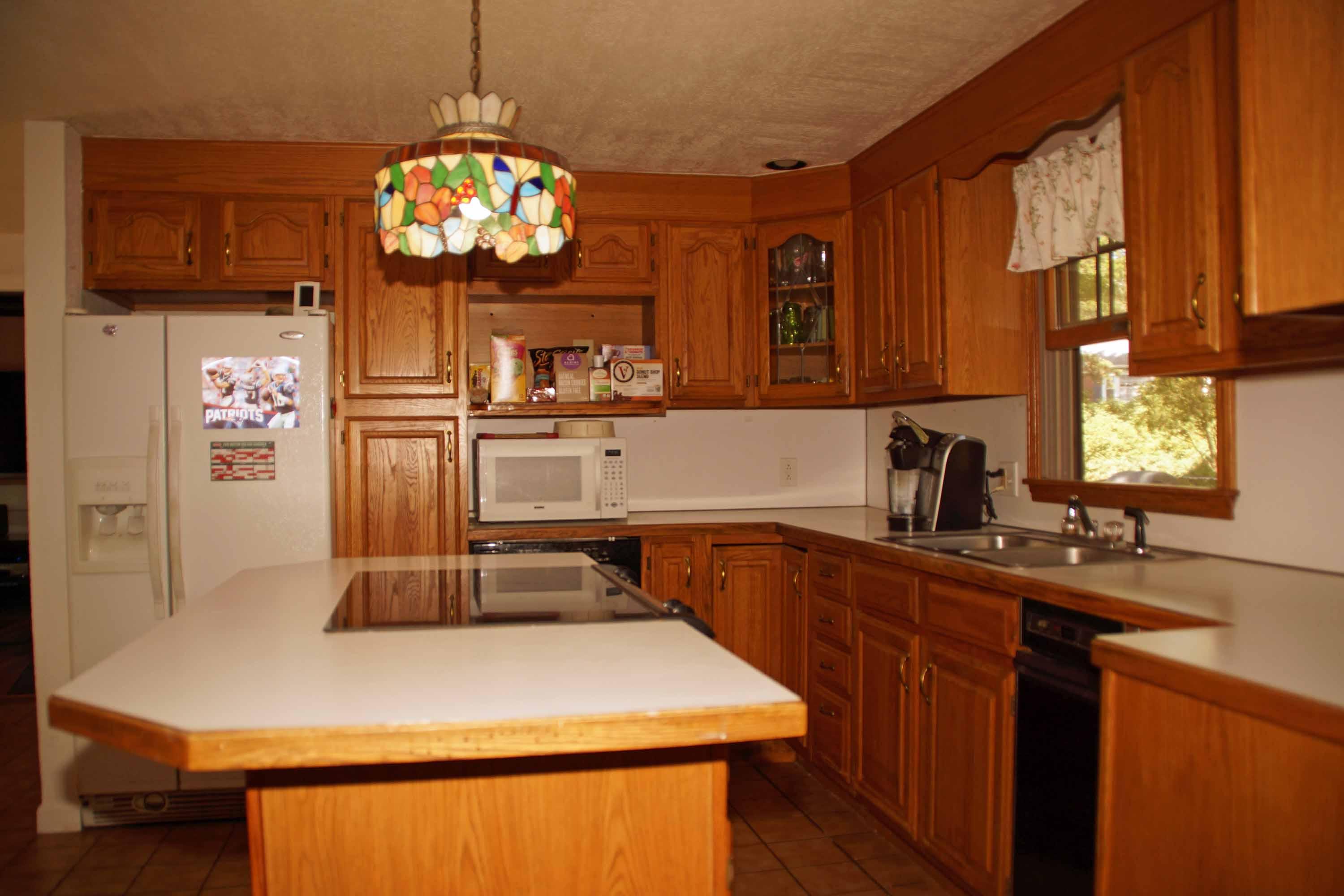 111 Azalea Drive Harwich, MA 02645 - Photo 8 of 26 a kitchen with stainless steel appliances a sink dishwasher and microwave with wooden floor