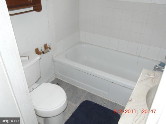 402-11 East 11th Avenue Ranson, WV 25438 - Photo 17 of 19 a white toilet sitting next to a bath tub