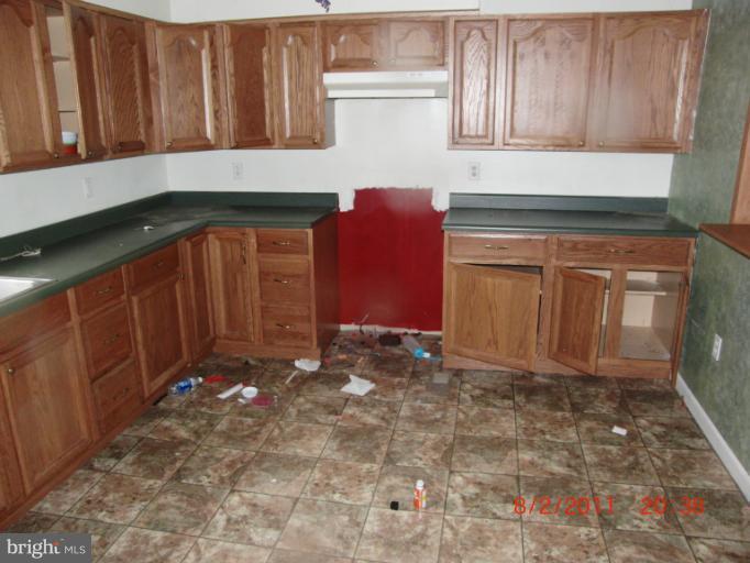 402-11 East 11th Avenue Ranson, WV 25438 - Photo 18 of 19 a kitchen with granite countertop a sink a stove and cabinets