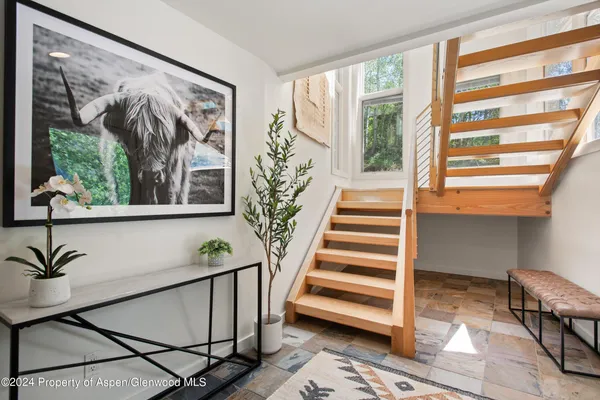 a view of a hallway with wooden floor and a large window