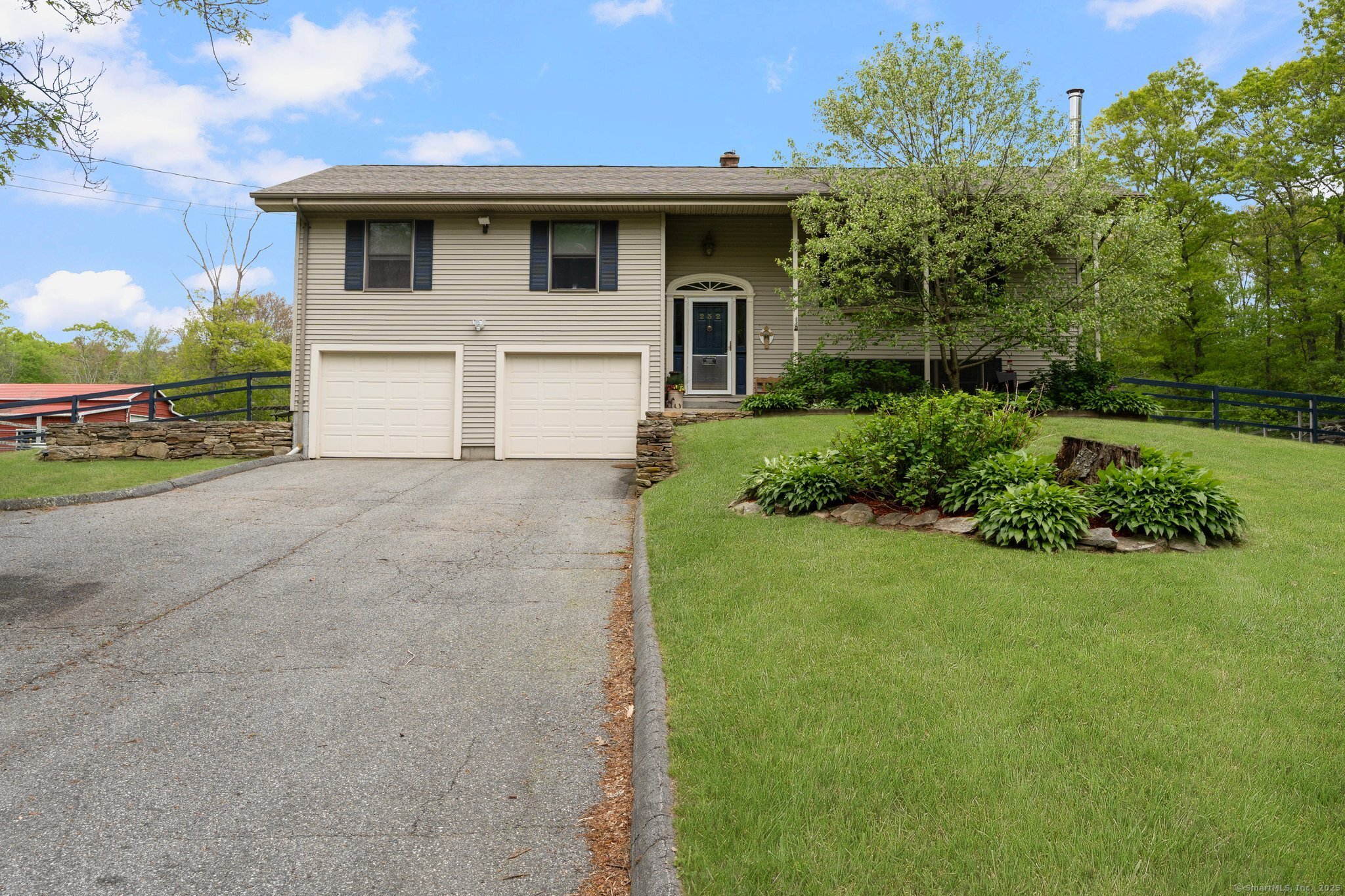 a white house that has a small yard and wooden fence