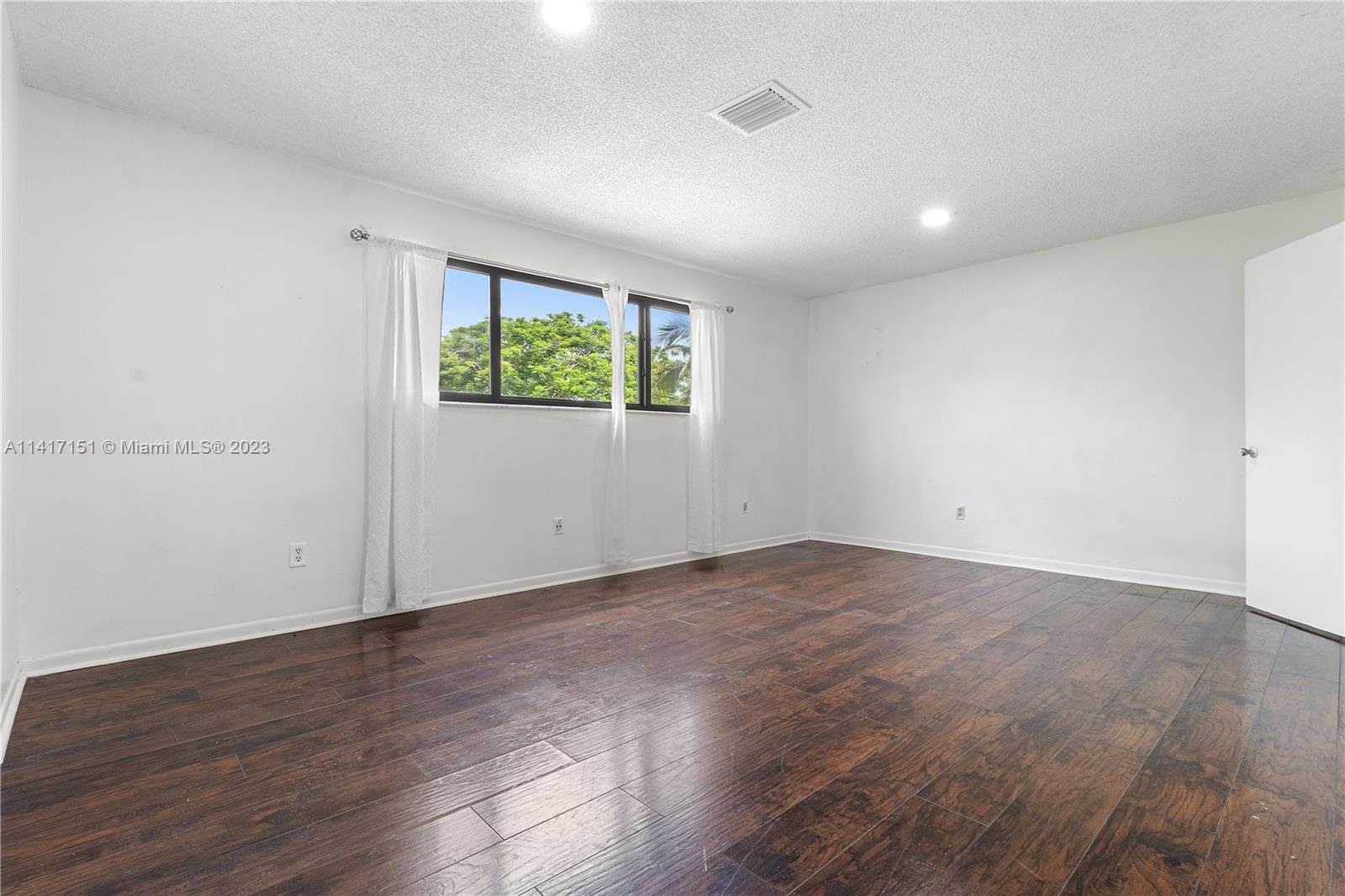 9435 Southwest 151st Avenue Miami, FL 33196 - Photo 13 of 35 an empty room with wooden floor and windows