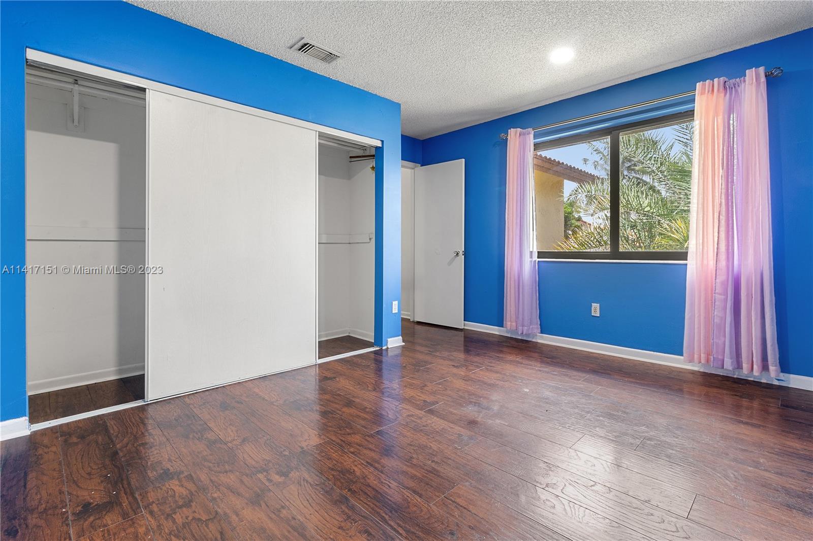 9435 Southwest 151st Avenue Miami, FL 33196 - Photo 16 of 35 a view of an empty room with wooden floor and a window