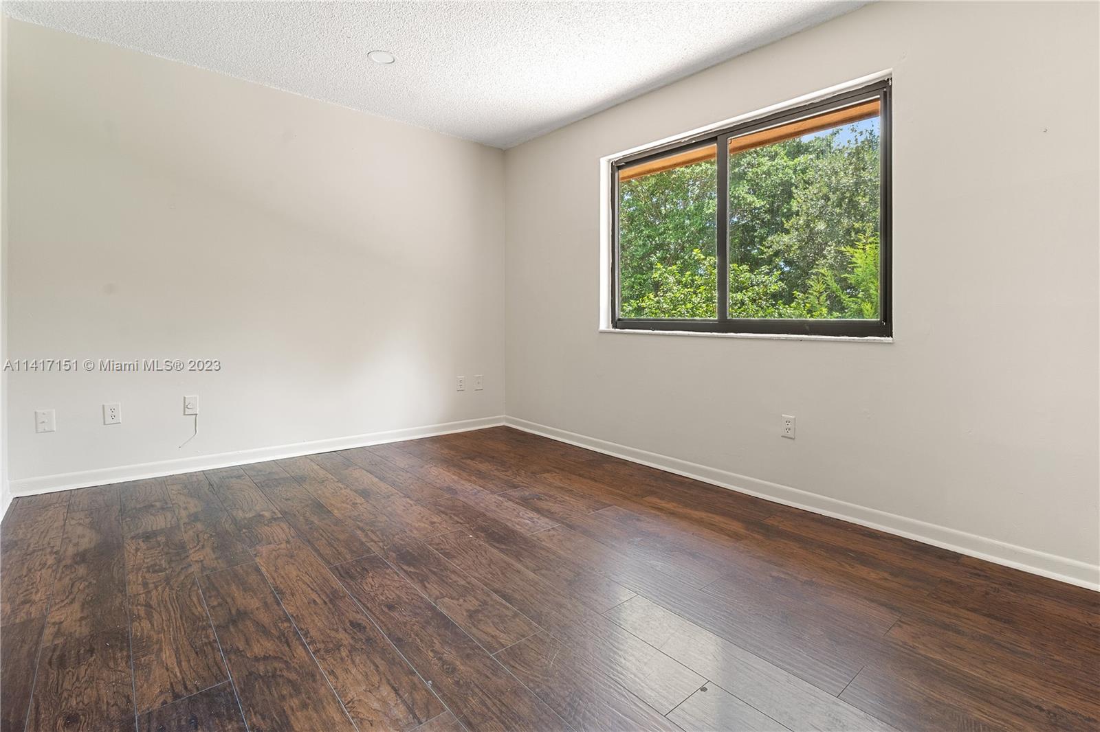 9435 Southwest 151st Avenue Miami, FL 33196 - Photo 18 of 35 an empty room with wooden floor and windows