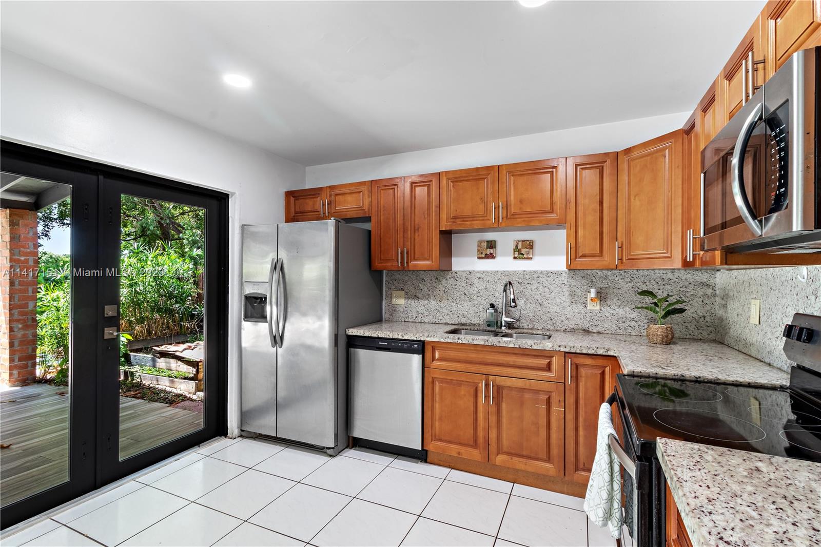 9435 Southwest 151st Avenue Miami, FL 33196 - Photo 6 of 35 a kitchen with stainless steel appliances granite countertop a stove a sink and a refrigerator