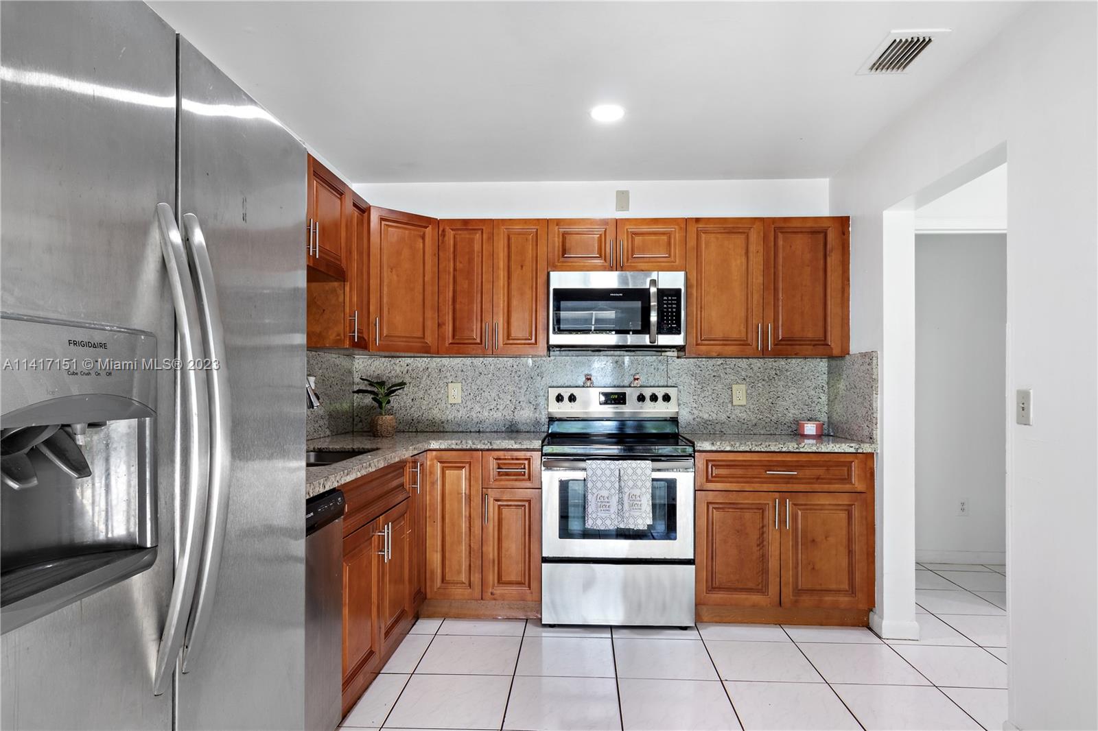 9435 Southwest 151st Avenue Miami, FL 33196 - Photo 7 of 35 a kitchen with stainless steel appliances granite countertop a refrigerator sink and microwave