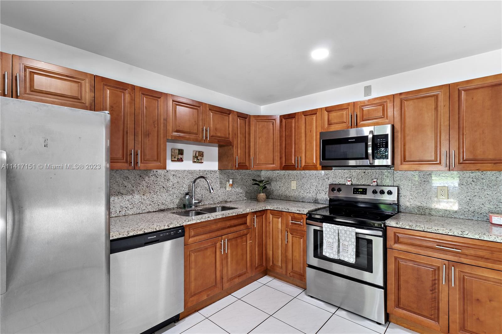 9435 Southwest 151st Avenue Miami, FL 33196 - Photo 8 of 35 a kitchen with stainless steel appliances granite countertop a sink stove microwave and refrigerator
