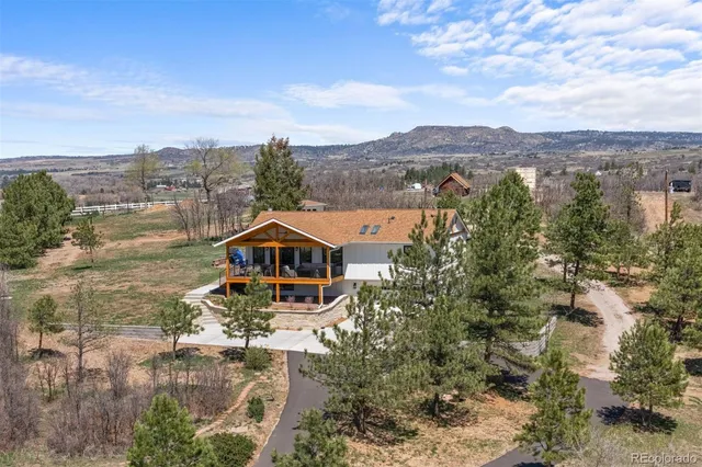 an aerial view of a house with a mountain in the background