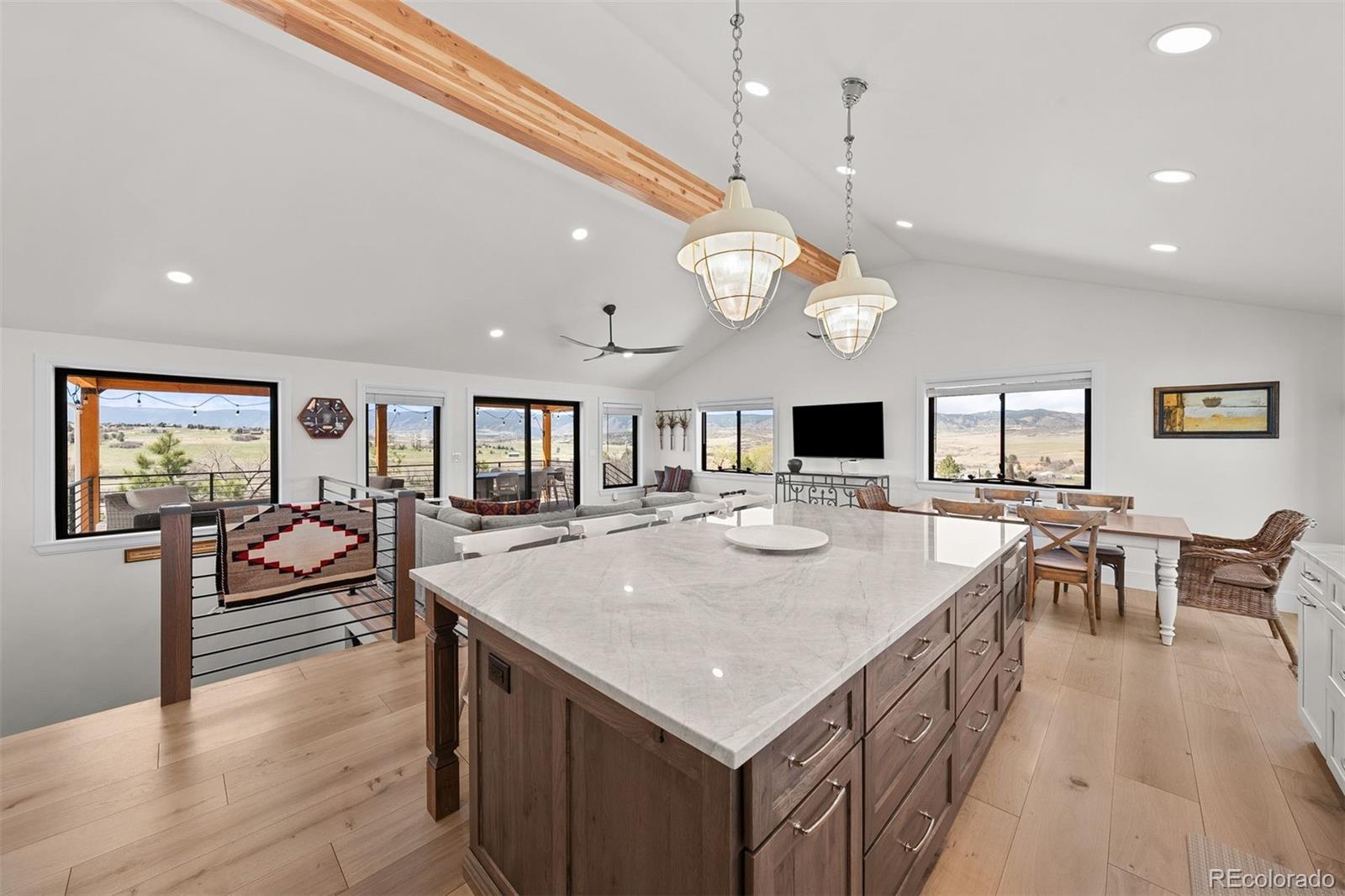 3303 West Wolfensberger Road Sedalia, CO 80135 - Photo 11 of 36 an open kitchen with a table and chairs