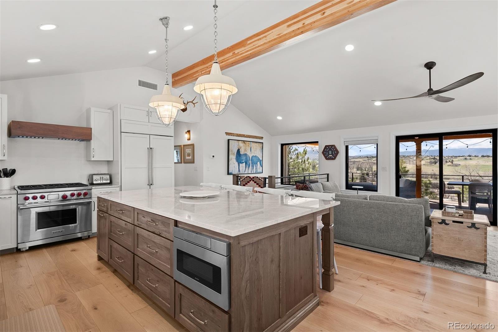 3303 West Wolfensberger Road Sedalia, CO 80135 - Photo 12 of 36 a large kitchen with stainless steel appliances granite countertop a stove and a large window
