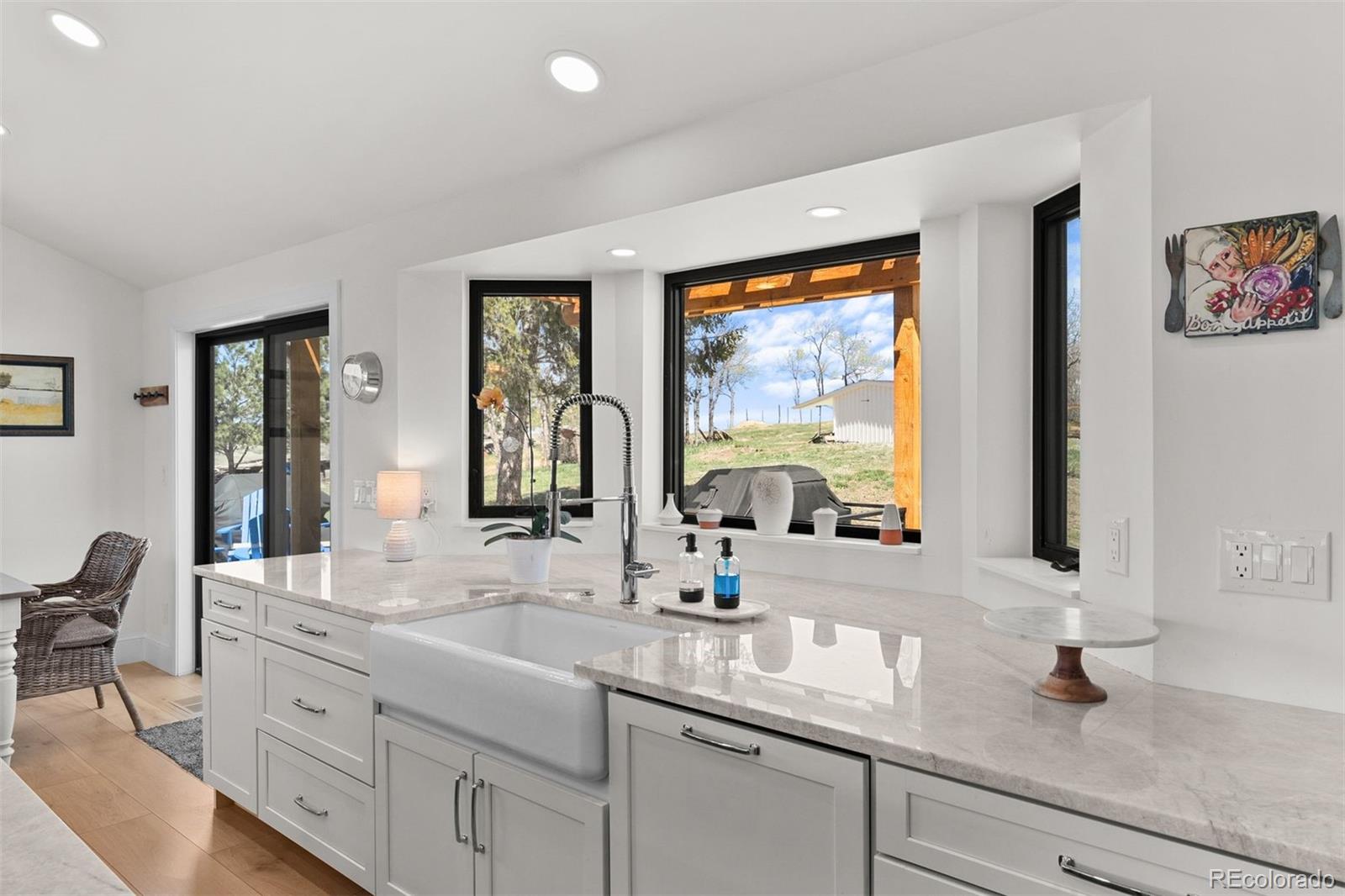 3303 West Wolfensberger Road Sedalia, CO 80135 - Photo 13 of 36 a bathroom with double vanity sinks a large mirror and a window