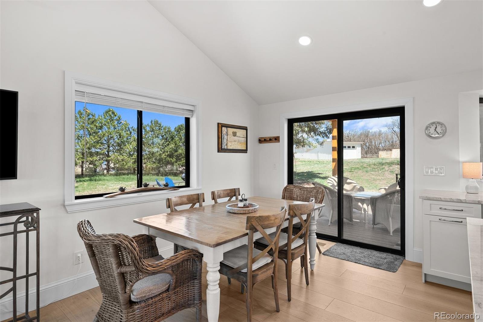 3303 West Wolfensberger Road Sedalia, CO 80135 - Photo 15 of 36 a view of a dining room with furniture large windows and wooden floor