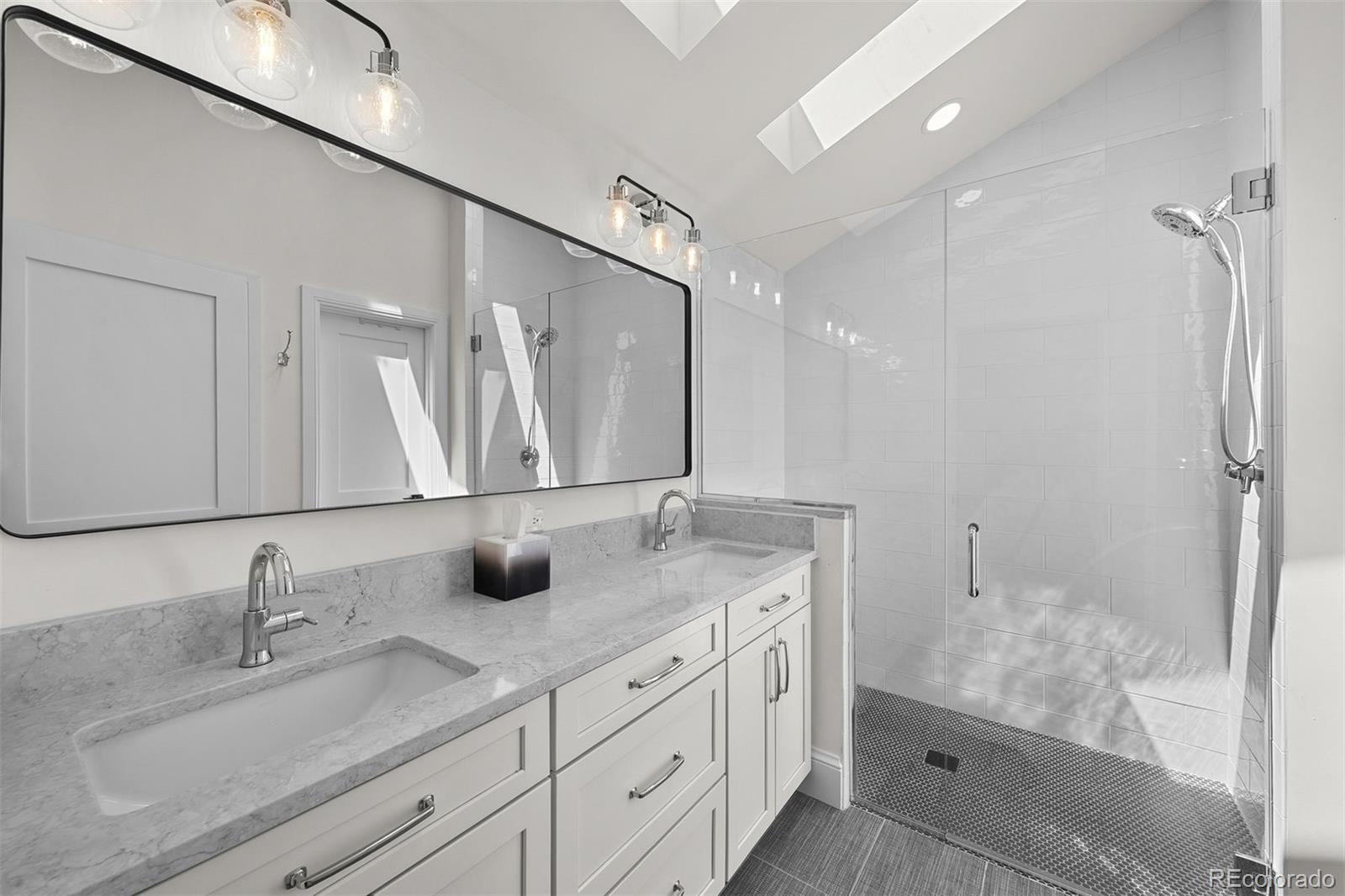 3303 West Wolfensberger Road Sedalia, CO 80135 - Photo 23 of 36 a bathroom with double sink and a mirror
