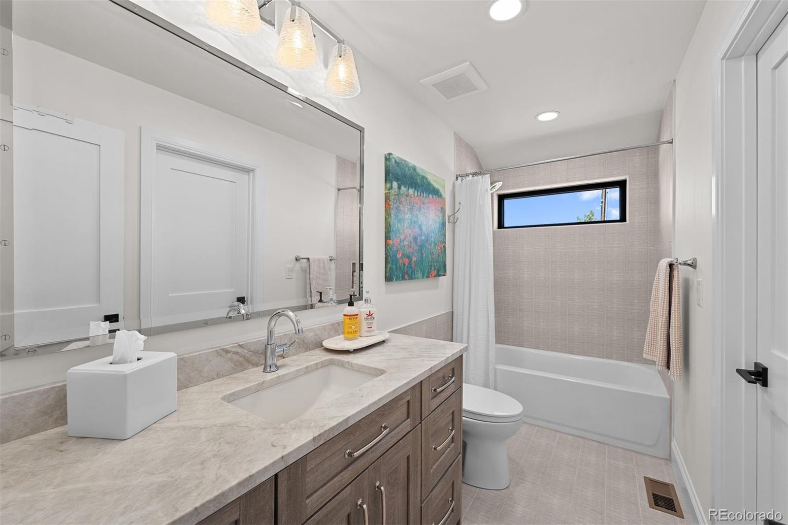 3303 West Wolfensberger Road Sedalia, CO 80135 - Photo 25 of 36 a bathroom with a granite countertop sink a toilet a mirror and shower