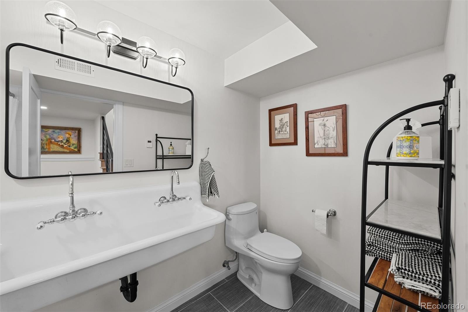 3303 West Wolfensberger Road Sedalia, CO 80135 - Photo 27 of 36 a bathroom with a toilet a sink and mirror