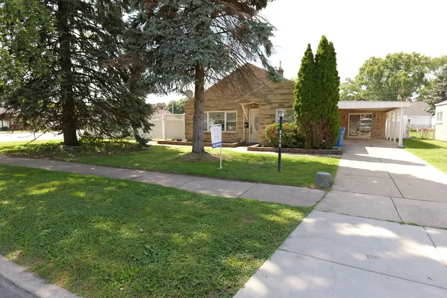 a view of a white house with a big yard and large trees