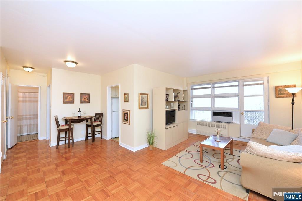 5 Roosevelt Place, Unit 2B Montclair, NJ 07042 - Photo 1 of 20 a living room with furniture a large window and dining table