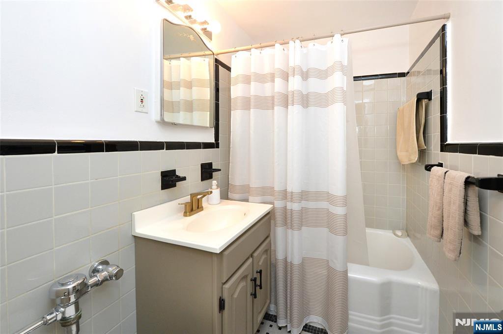 5 Roosevelt Place, Unit 2B Montclair, NJ 07042 - Photo 6 of 20 a bathroom with a sink a mirror and a shower