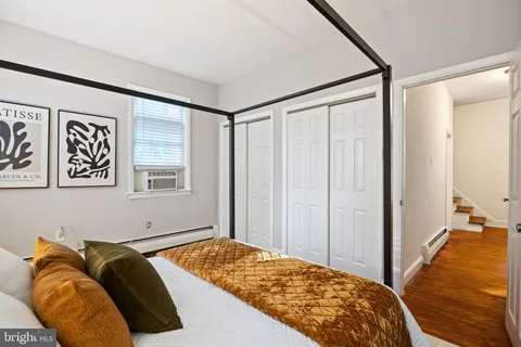 a bedroom with a bed and a painting on the wall