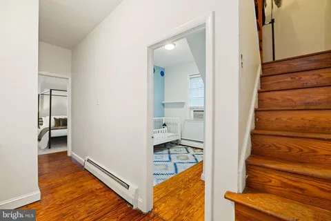 a view of a hallway with wooden floor and staircase