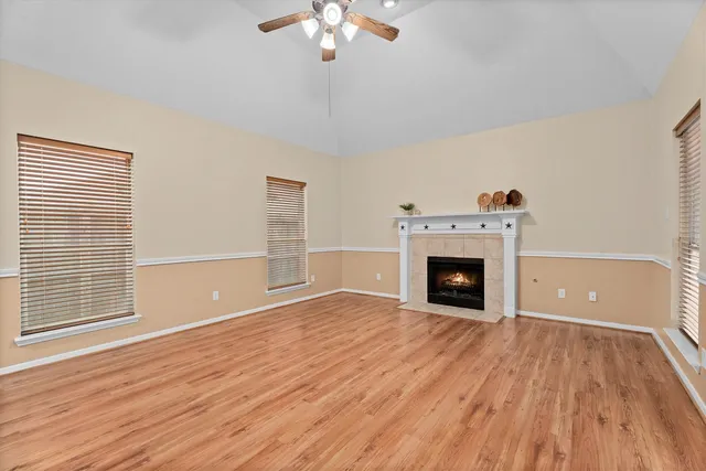 a view of a livingroom with a fireplace wooden floor and a chandelier