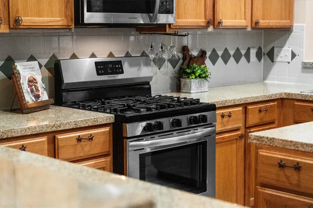 a kitchen with stainless steel appliances granite countertop a stove and a microwave