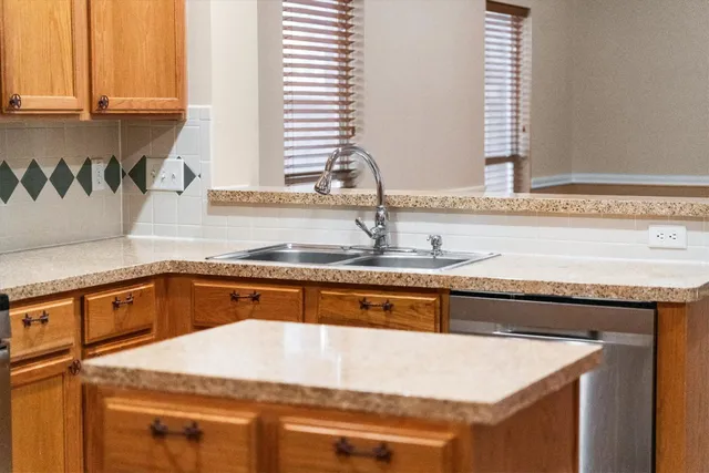 a kitchen with stainless steel appliances granite countertop a sink and a white cabinets