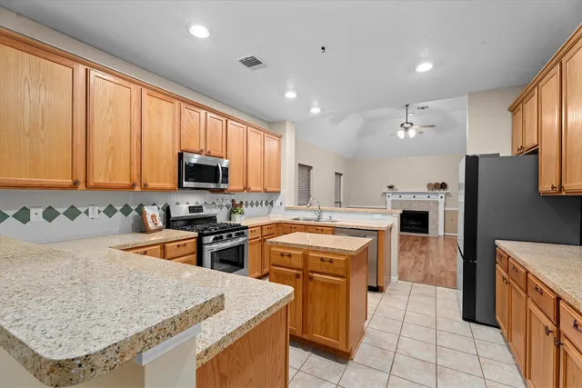 a kitchen with stainless steel appliances granite countertop a refrigerator stove microwave and sink