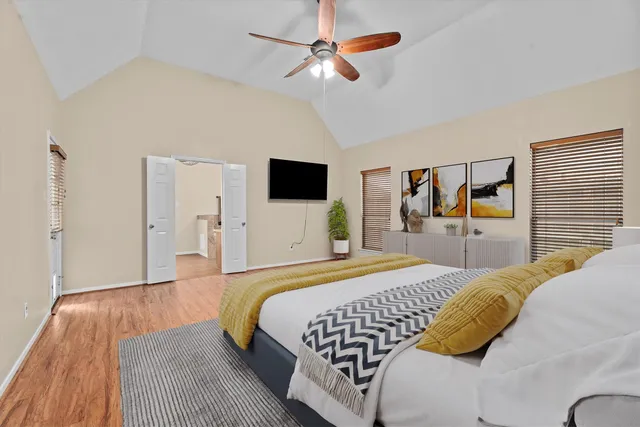 a bedroom with a bed and a flat tv screen on dresser