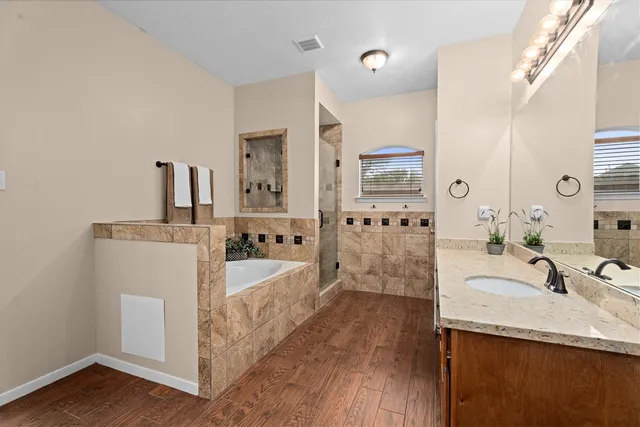 a bathroom with a granite countertop sink a mirror and shower