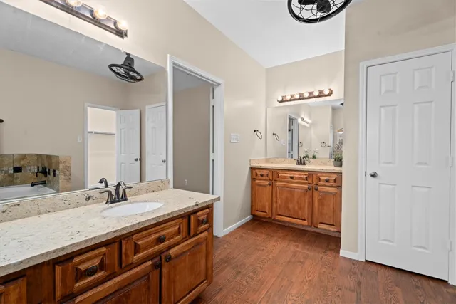 a bathroom with a granite countertop sink a mirror and a bathtub