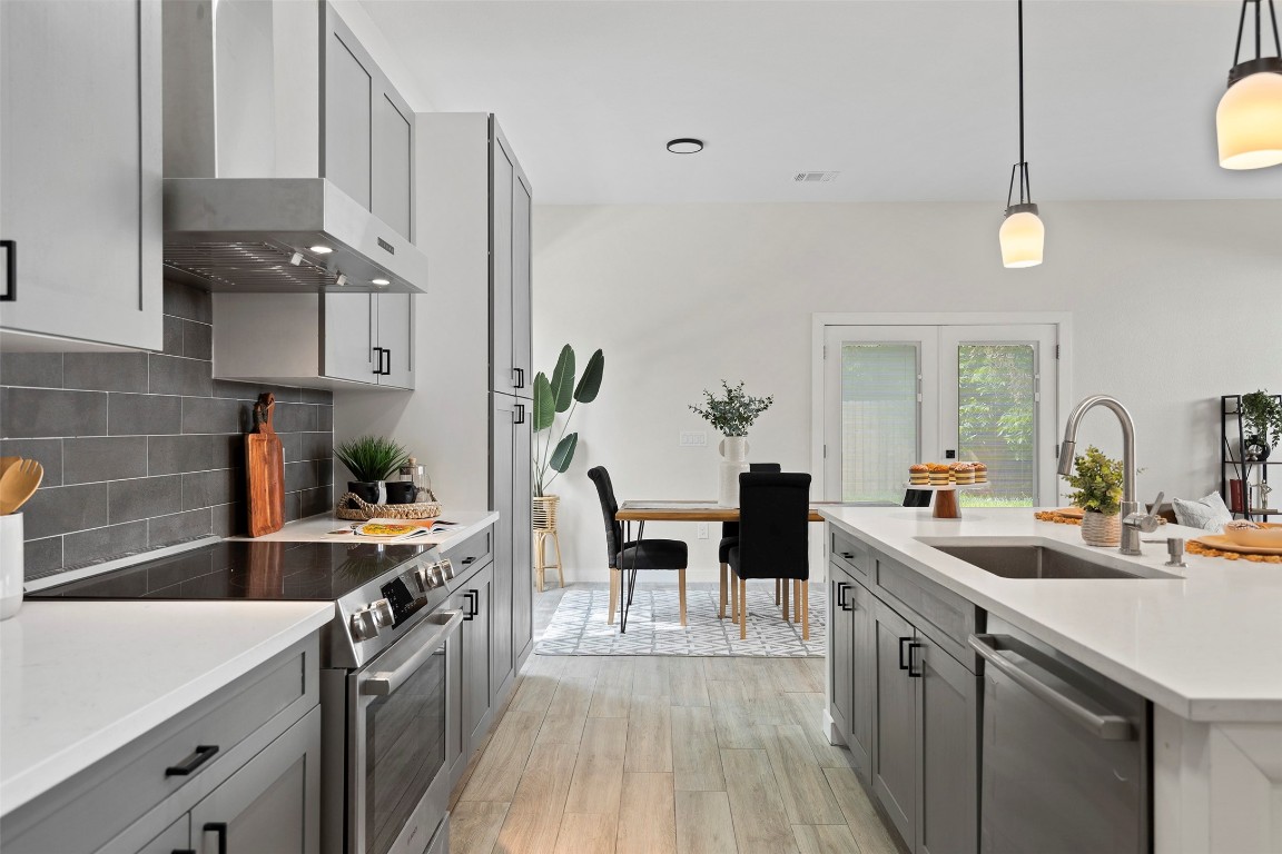 3611 Munson Street Austin, TX 78721 - Photo 20 of 40 a kitchen with stainless steel appliances a sink a counter space and wooden floor