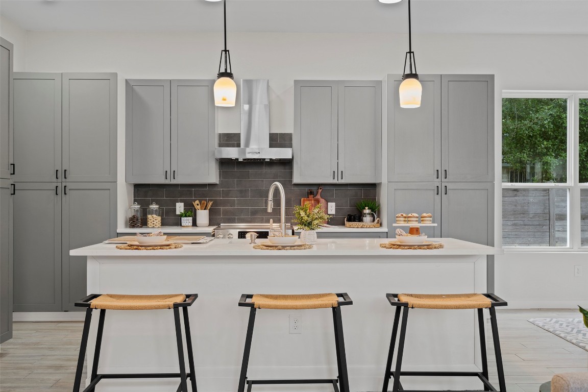 3611 Munson Street Austin, TX 78721 - Photo 10 of 40 a kitchen with stainless steel appliances granite countertop a stove a sink and white cabinets with wooden floor