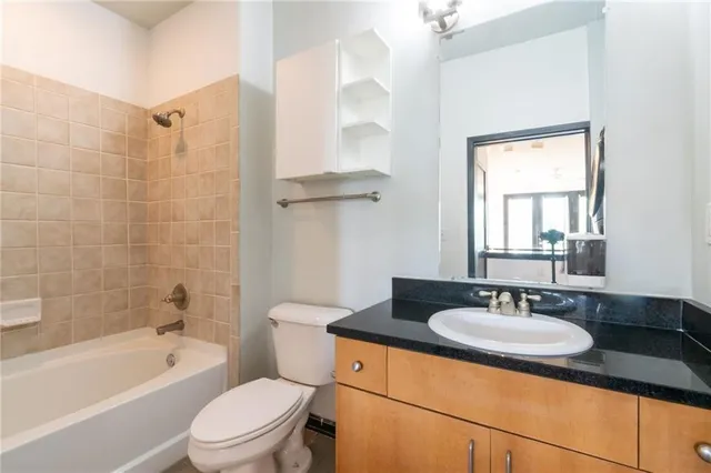 a bathroom with a granite countertop sink toilet and shower