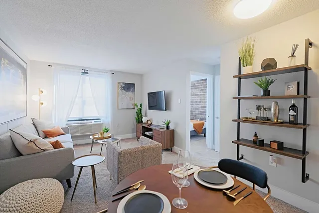 a living room with furniture kitchen view and a window