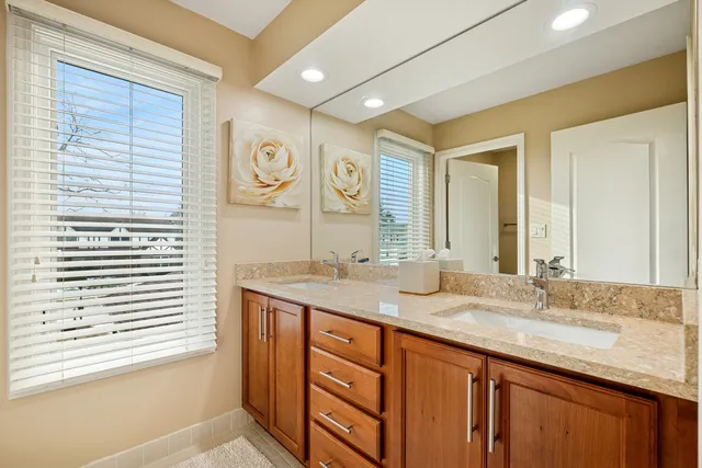 a bathroom with a granite countertop sink and a large mirror