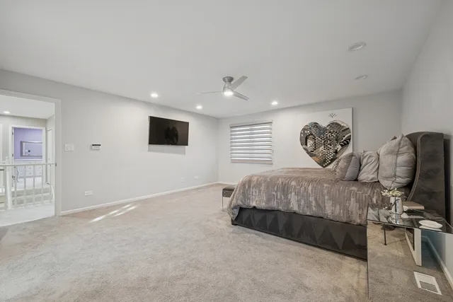 a spacious bedroom with a bed and wooden floor