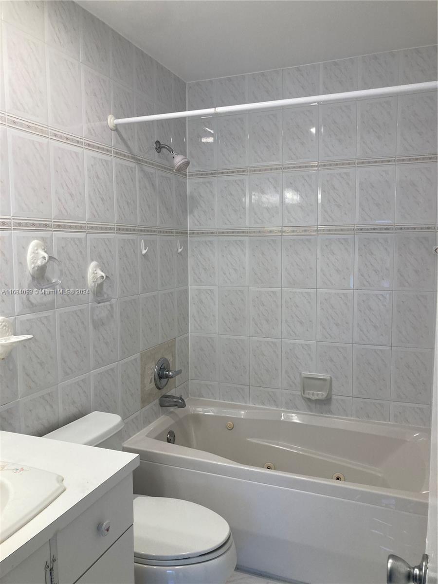 13731 Southwest 84th Street, Unit E Miami, FL 33143 - Photo 18 of 19 a bathroom with a sink a toilet and shower