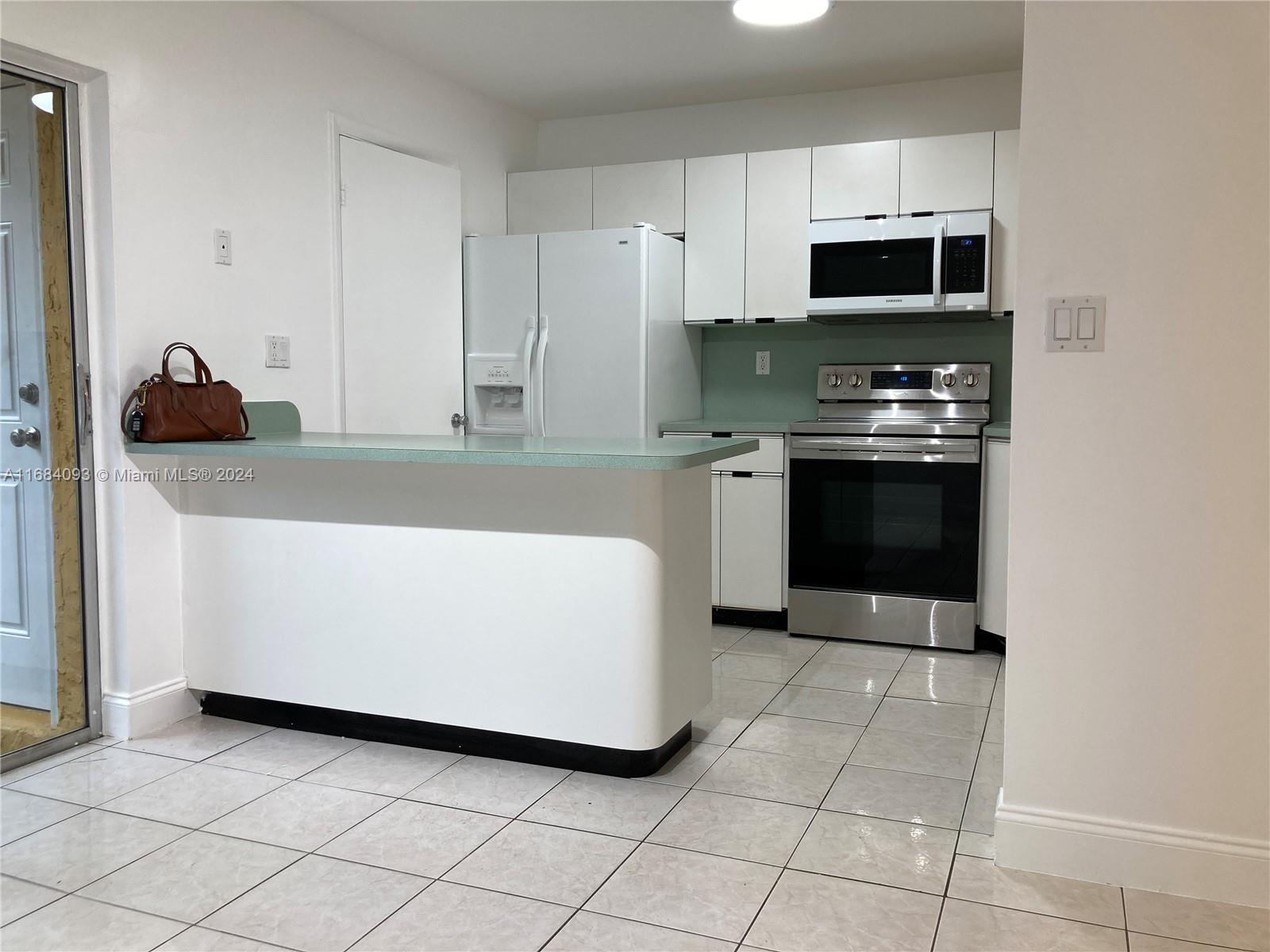 13731 Southwest 84th Street, Unit E Miami, FL 33143 - Photo 3 of 19 a kitchen with a sink and a stove top oven