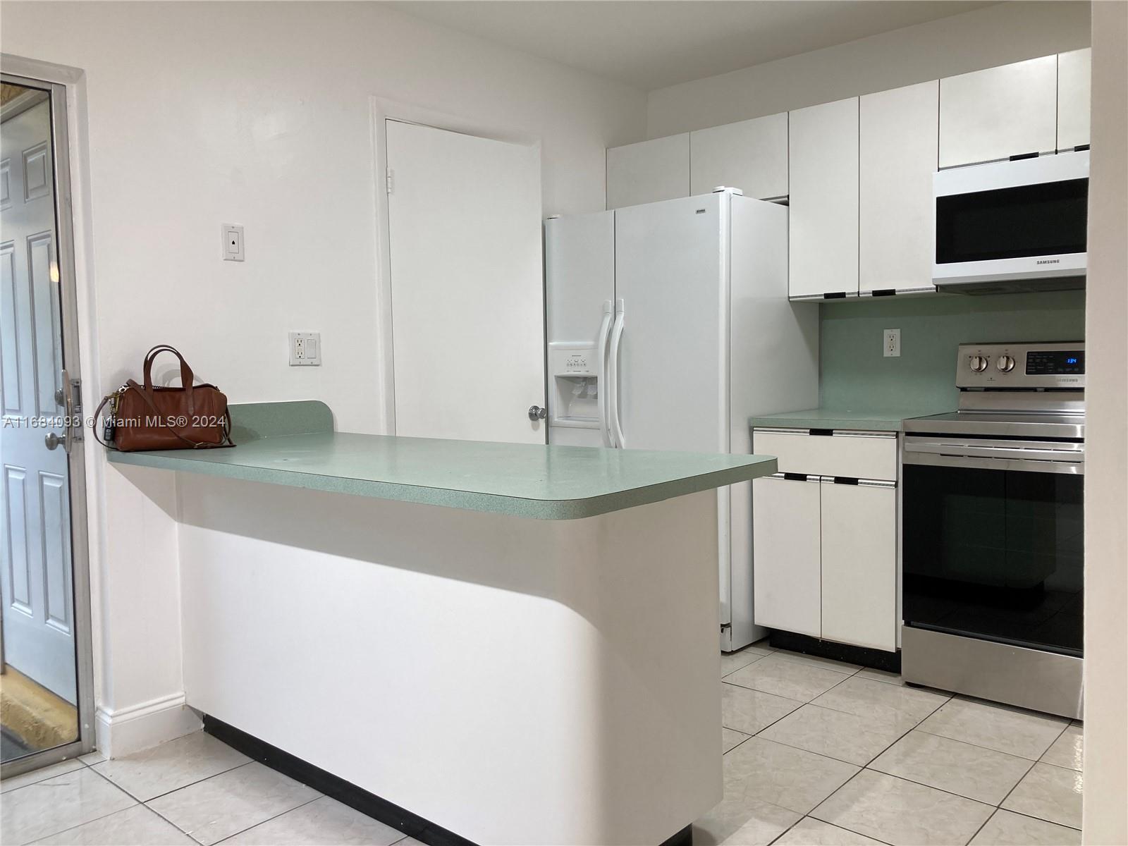 13731 Southwest 84th Street, Unit E Miami, FL 33143 - Photo 4 of 19 a kitchen with a stove and a refrigerator