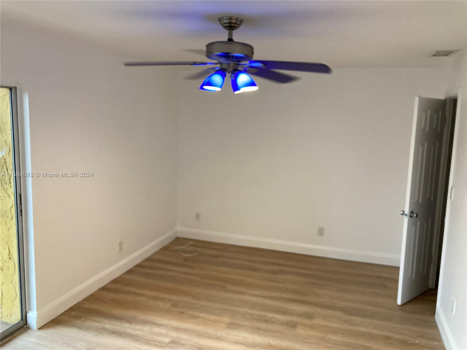 13731 Southwest 84th Street, Unit E Miami, FL 33143 - Photo 10 of 19 an empty room with wooden floor and fan