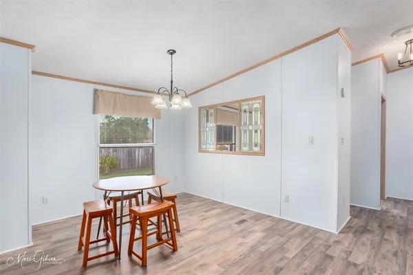 a dining room with furniture a chandelier and wooden floor