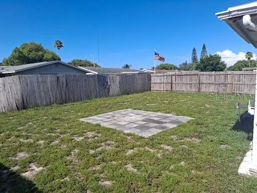a view of a backyard with wooden fence