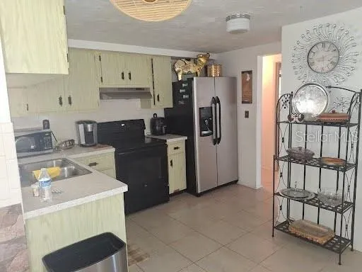 a kitchen with a refrigerator and a stove top oven