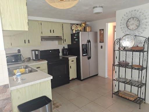 3600 Darlington Road Holiday, FL 34691 - Photo 7 of 20 a kitchen with a refrigerator and a stove top oven